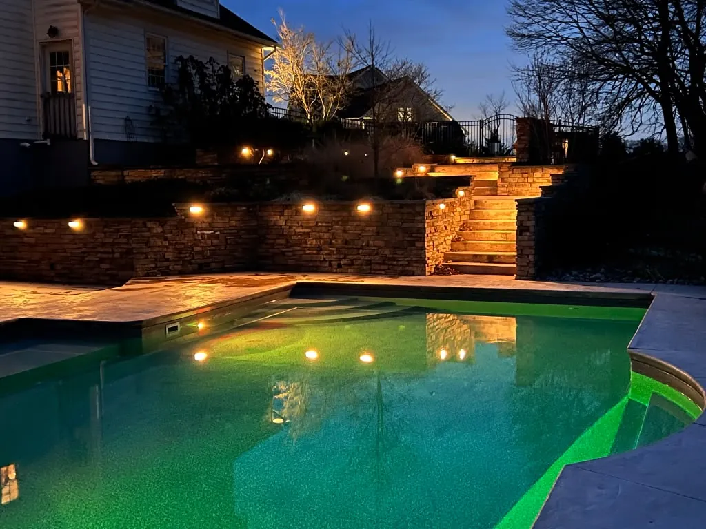 Pool and lit stone stairway at dusk