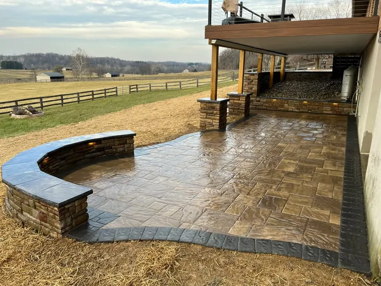 Curved stone seat wall around wet look paver patio